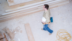 Construction worker carrying plans