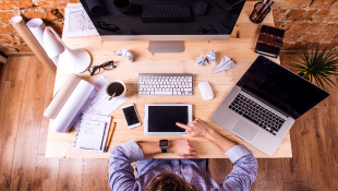 Businessman surrounded by computer and technology