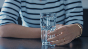 Person holding glass of water