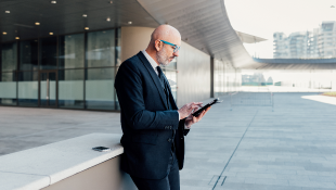 Businessman holding laptop outside