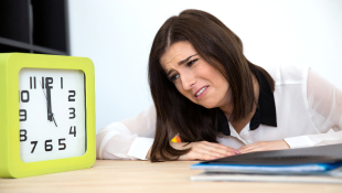 Businesswoman next to clock