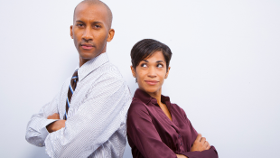 Two business people in dispute standing back to back