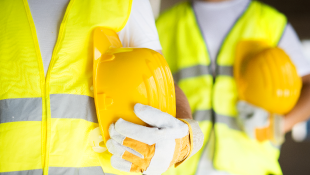 Construction workers holding hardhats no faces