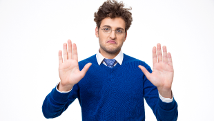 Businessman raises hands in stop gesture