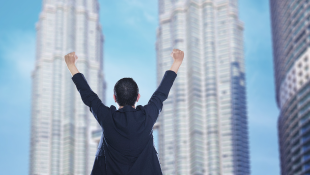 Businesswoman with arms up in triumph